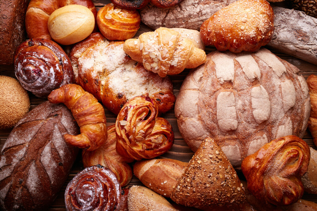 Pains et petits pains frais et savoureux sur fond en bois.
