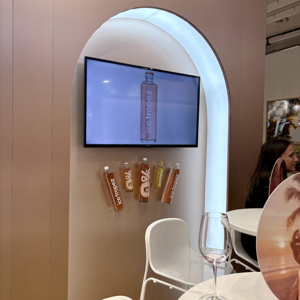 Alcove avec écran LCD et bouteilles fixées au mur de la réserve stand Wine Paris